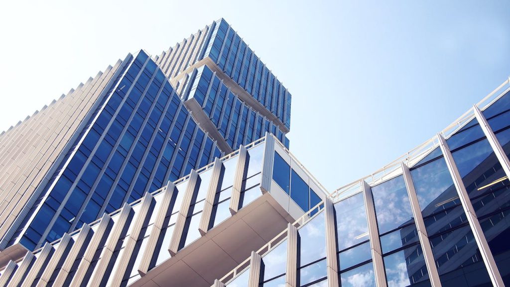 The Art of Drawing Readers In: Your attractive post title goes here Low-angle shot of a modern skyscraper with reflective glass design under a clear blue sky.